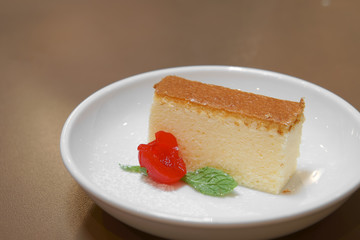 delicious cherry cheese cake in white dish on the wood table and warm white light at bakery cafe for sweet dessert or snack with space for text