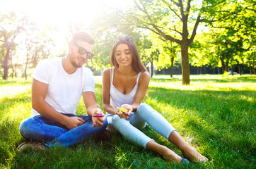 Young girl and boy playing with a fidget spinners in the park. stress relieving toy. Sunny summer...