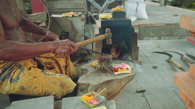 Balinese iron smith making tools traditional way in village, slide left