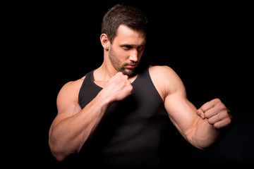 Fighter silhouette. Handsome athletic man in boxing stand on a dark background.