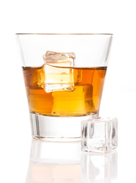 Glass of whiskey with ice on white background