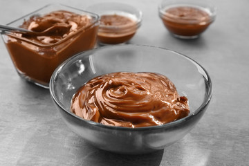 Glass bowl with tasty caramel sauce on table