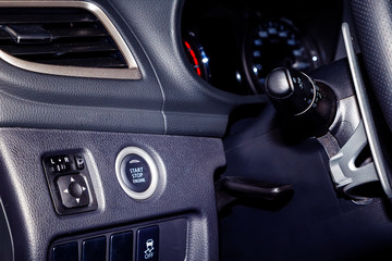 Plakat start engine button on the panel near the steering in modern car