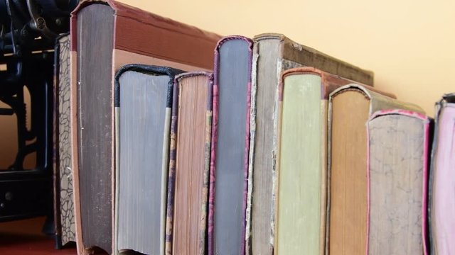 Vintage books. View of row of old books and vintage typewriter