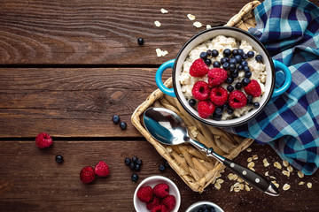 Oatmeal porridge with fresh berries, oats with blueberry and raspberry - obrazy, fototapety, plakaty