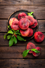 Peach, saturn or donut peaches with leaves