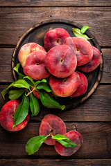 Peach, saturn or donut peaches with leaves