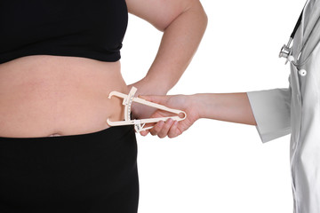 Doctor examining stout woman on white background. Weight loss concept