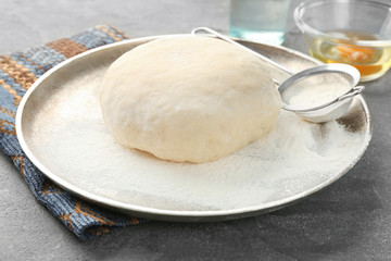Tray with raw dough on grey table