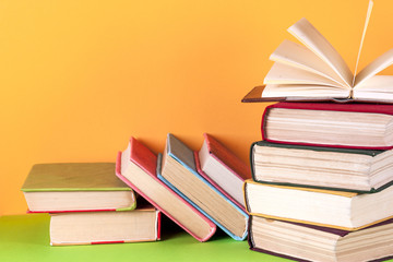 Open book, hardback books on bright colorful background.