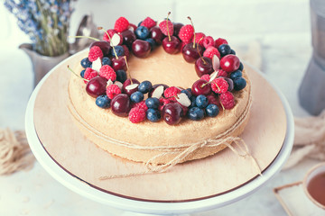 Cheesecake with summer berries on wooden stand. Close up. Rustic eco style