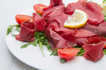 dish of bresaola and aragula