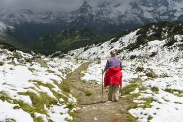 Senior Woman Hiking Through Snowy Mountains, Austria