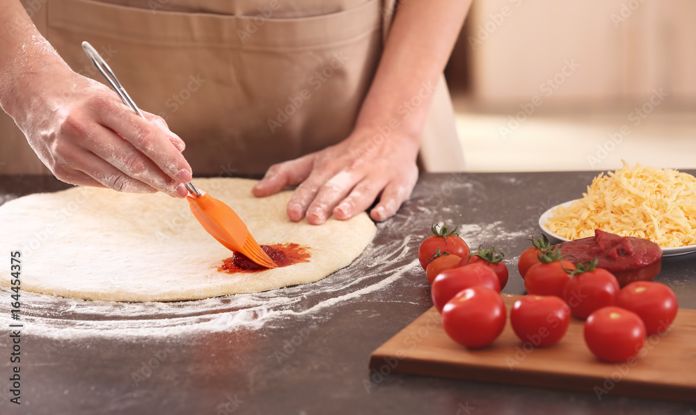 Sticker Woman preparing pizza at kitchen table