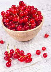 Fresh ripe red currants on rustic wood background.