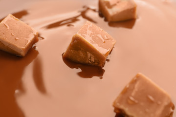 Tasty caramel sauce and candies, closeup