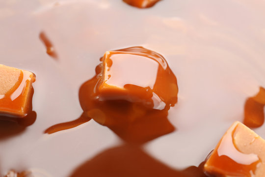 Tasty caramel sauce and candies, closeup