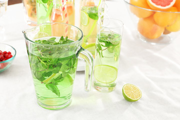 Glassware with refreshing lemonade on table