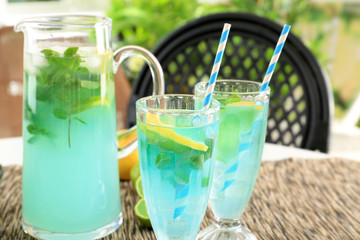 Glassware with refreshing lemonade on table outdoor