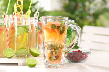 Glassware with different kinds of lemonade on table outdoor