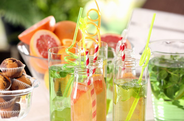 Glassware with different kinds of lemonade on table outdoor