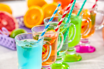 Glasses with different kinds of lemonade on table
