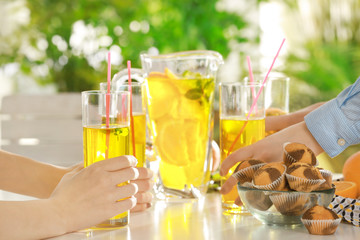 Women with glasses of refreshing lemonade on table