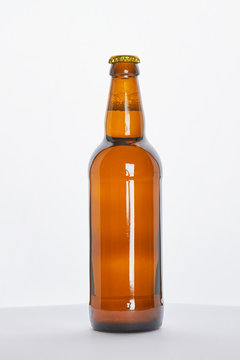 Brown bottle with fresh beer. Transparent object with alcohol liquid.