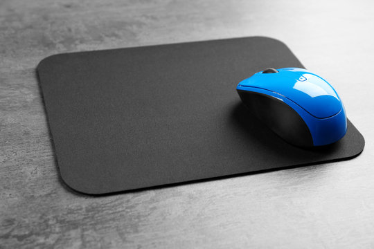Blank mat and wireless mouse on textured background