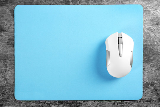 Blank mat and wireless mouse on textured background