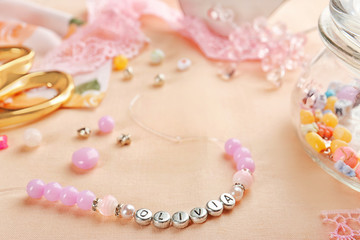 Bracelet with baby name OLIVIA and accessories on light cloth