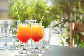 Glasses of delicious tequila sunrise cocktails on table