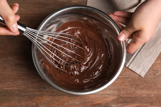 Woman Stirring Delicious Chocolate Sauce In Bowl With Whisk On Table