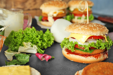 Composition with tasty homemade burger and vegetables on table