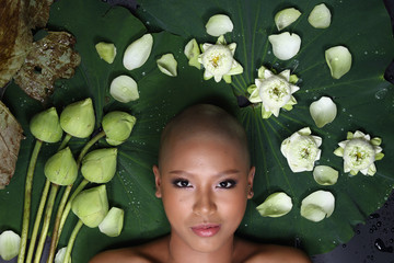 Skin Head Girl on Lotus flower and banana leaf with drop of water, shadow and depth of field