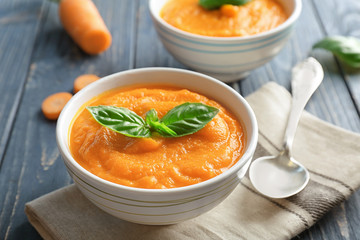 Delicious carrot soup on wooden table