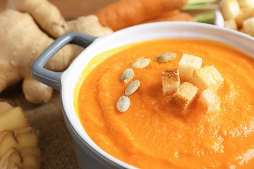 Delicious carrot soup on table, closeup