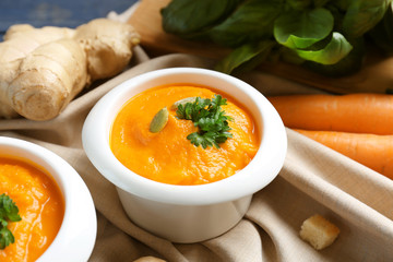 Delicious carrot soup on table