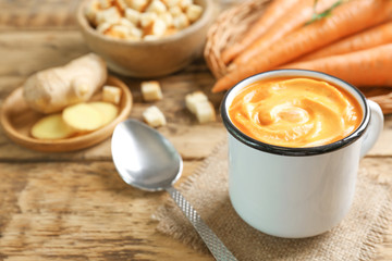 Delicious carrot soup on wooden table
