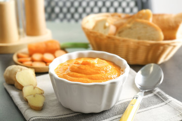 Delicious carrot soup on table