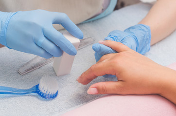 The master prepares the nails for manicure
