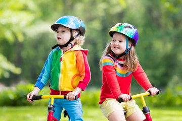 Fototapeta na wymiar Kids ride balance bike in park