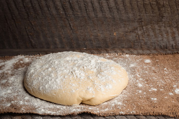 Ball of dough for pizza on the background of rustic