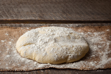 Ball of dough for pizza on the background of rustic