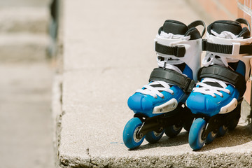 Fototapeta na wymiar Toned Roller inline skates in skate park on gray urban background