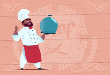 African American Chef Cook Holding Tray With Dish Smiling Cartoon In White Restaurant Uniform Over Wooden Textured Background Flat Vector Illustration