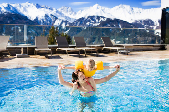 Family in outdoor swimming pool of alpine spa resort