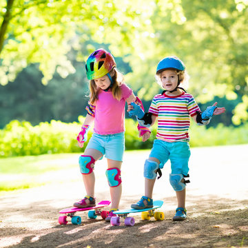 Children riding skateboard in summer park