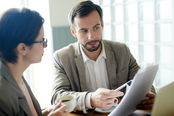 Agent reading and explaining business contract to one of partners