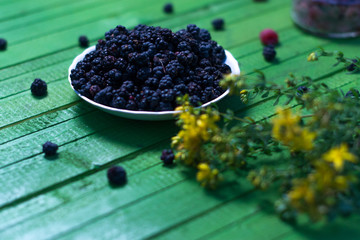 Fresh blackberries on a wooden green background.